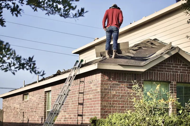 Professional roofer working on a residential roof in Weldon